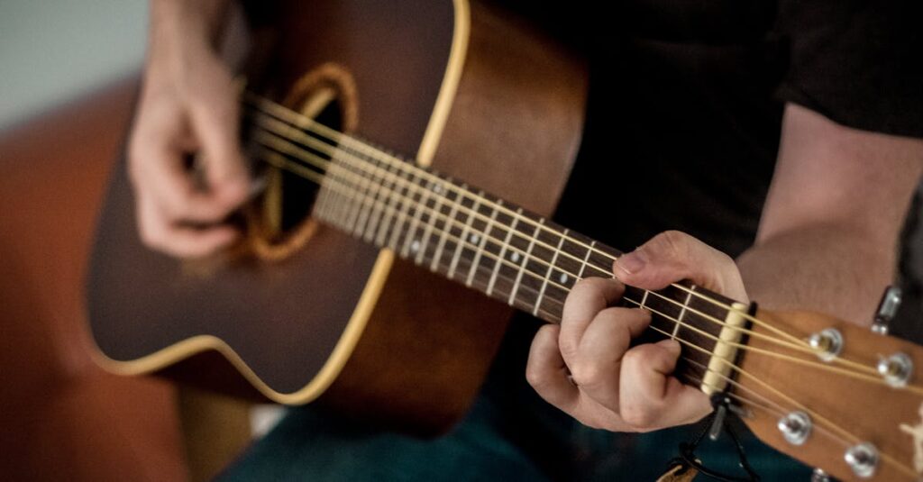 A musician strums chords on an acoustic guitar, showcasing musical talent.